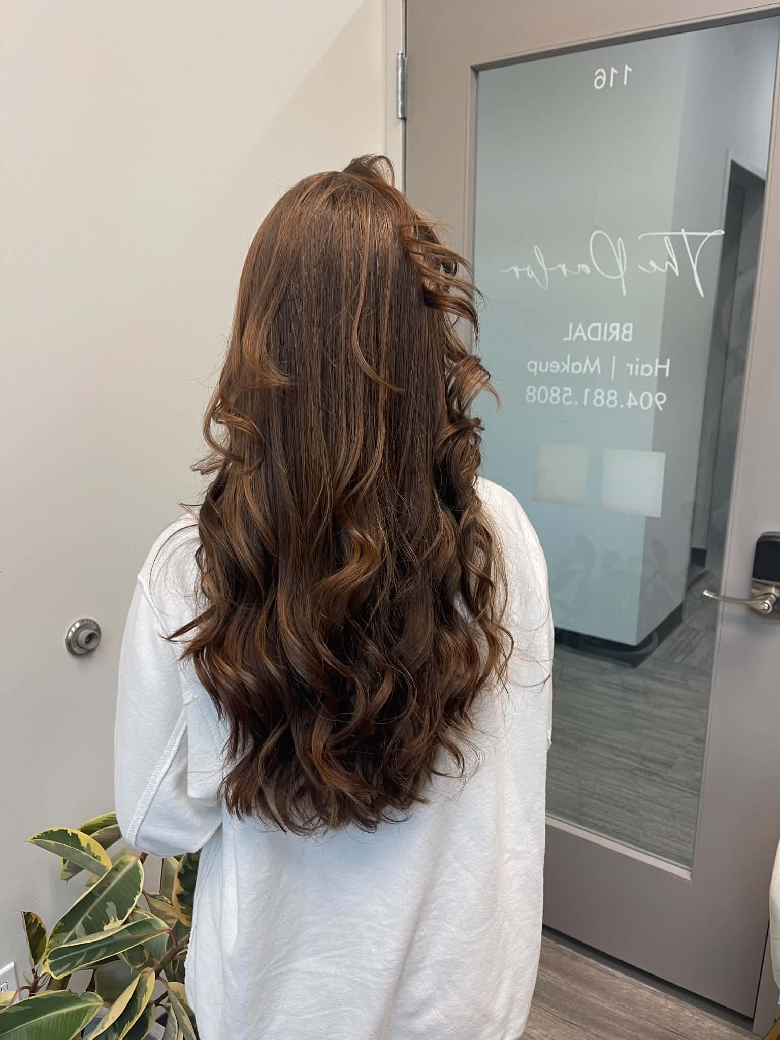 Long glossy brunette hair styled in soft curls
