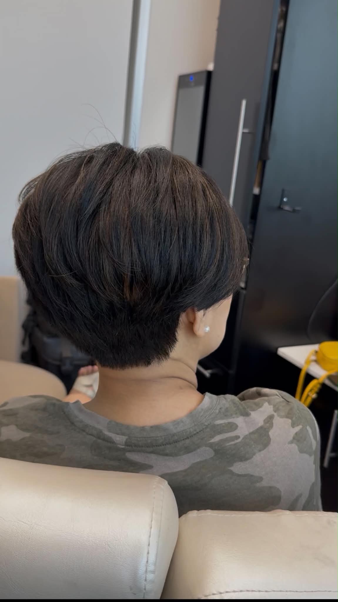 Short dark pixie haircut with a precise tapered silhouette